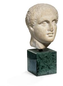 Romersk hoved af marmor i form af antagelig en bokser. Romersk kejsertid. På stand af grøn granit. H. 10 cm.